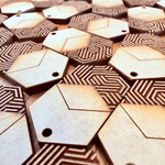 Unfinished batch of laser-cut wooden earring pieces showing the process before painting and gilding.